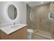 Stylish bathroom with illuminated round mirror, glass-enclosed shower and modern fixtures at 301 Quay Commons # 1411, Sarasota, FL 34236