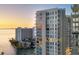 Exterior of high-rise condo with multiple stories of balconies overlooks the water at sunset at 301 Quay Commons # 1411, Sarasota, FL 34236