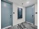 Hallway features two entrance doors, a patterned floor, and modern wall art at 301 Quay Commons # 1411, Sarasota, FL 34236