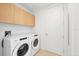 Convenient laundry room with front load washer and dryer and storage cabinets above at 301 Quay Commons # 1411, Sarasota, FL 34236