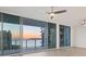 Bright living room boasts expansive windows with sunset water views, creating a serene and luxurious living experience at 301 Quay Commons # 1411, Sarasota, FL 34236