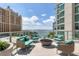 Enjoy breathtaking waterfront views from this stylish patio with modern seating and a cozy fire pit at 301 Quay Commons # 1411, Sarasota, FL 34236