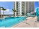 Luxury rooftop pool with lounge chairs and umbrellas for relaxation at 301 Quay Commons # 1411, Sarasota, FL 34236