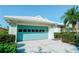 Bright garage with a teal garage door, and ample parking space, set against the well-maintained exterior of the home at 308 Bermuda Ct # 13, Venice, FL 34293