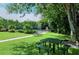 Relaxing community picnic area with tables under shade trees near tennis courts at 360 Gulf Of Mexico Dr # 332, Longboat Key, FL 34228