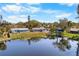 Scenic aerial view of a home situated on a waterfront property, reflecting trees against a blue sky at 3718 61St St, Bradenton, FL 34209