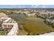 Aerial view of community with lake, surrounding apartments, and beautiful waterfront views at 4126 Heron Way # B113, Bradenton, FL 34205