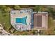 Aerial view of a community pool with lounge chairs and tables, and lush landscaping at 4126 Heron Way # B113, Bradenton, FL 34205