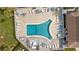 Aerial view of a community pool with lounge chairs and tables by the clubhouse at 4126 Heron Way # B113, Bradenton, FL 34205