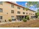 Multi-story exterior featuring tan siding, covered porch, landscaping, and a grassy area at 4126 Heron Way # B113, Bradenton, FL 34205