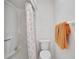 Bathroom features a shower with a patterned curtain and an orange towel on the wall at 4565 Mohican Trl # 129, Sarasota, FL 34233