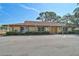 Exterior view of the community clubhouse with ample parking and manicured landscaping at 4565 Mohican Trl # 129, Sarasota, FL 34233