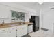 Cozy kitchen area with white cabinets, stainless steel appliances, and a bright window view at 4565 Mohican Trl # 129, Sarasota, FL 34233