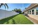 Expansive backyard featuring a pristine white fence, lush green grass, and a well-manicured lawn at 4616 Park Acres Dr, Bradenton, FL 34207