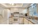 Kitchen featuring white cabinets, tile backsplash, and stainless steel sink under a window at 4616 Park Acres Dr, Bradenton, FL 34207