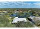 Aerial view of a home with a beautiful lake view, surrounded by lush trees and blue skies at 4749 Antler Trl, Sarasota, FL 34238