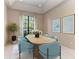 Bright dining room featuring a modern light wood table and blue upholstered chairs at 4749 Antler Trl, Sarasota, FL 34238