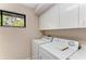 Bright laundry room featuring a washer and dryer, cabinets and natural light at 4749 Antler Trl, Sarasota, FL 34238