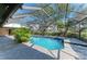 A screened-in pool with spa is surrounded by tile and landscaping at 4749 Antler Trl, Sarasota, FL 34238