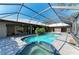 Covered pool and spa are surrounded by patio and green landscaping at 4749 Antler Trl, Sarasota, FL 34238