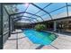 Covered pool and spa are surrounded by patio and green landscaping at 4749 Antler Trl, Sarasota, FL 34238