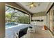 Covered patio with chairs and a sink, overlooking the pool and green surroundings at 4749 Antler Trl, Sarasota, FL 34238