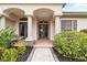 Elegant entryway with arched columns, double doors and lush landscaping at 4921 Woodhurst Dr, Sarasota, FL 34243