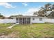 View of the backyard, featuring a screened-in patio and white fencing at 4925 Silk Oak Dr, Sarasota, FL 34232