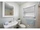 Cozy bathroom features a pedestal sink, toilet, and shower with beige tiling, plus a window for natural light at 4925 Silk Oak Dr, Sarasota, FL 34232