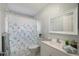 Well-lit bathroom with a vanity, toilet, and decorative shower curtain, providing a refreshing space at 4925 Silk Oak Dr, Sarasota, FL 34232