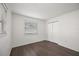 Bedroom with wood-look flooring, double closet, and a bright window at 4925 Silk Oak Dr, Sarasota, FL 34232