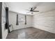 Bright bedroom featuring wood-look flooring, a stylish ceiling fan, and a decorative wood accent wall at 4925 Silk Oak Dr, Sarasota, FL 34232