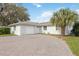 A well-maintained house with a white garage door and a brick driveway leading up to the front door at 4925 Silk Oak Dr, Sarasota, FL 34232