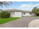 A well-maintained house with a green lawn, a brick driveway, and white window shutters at 4925 Silk Oak Dr, Sarasota, FL 34232