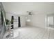 A bright living room with a ceiling fan, tile floors, and an accent wall at 4925 Silk Oak Dr, Sarasota, FL 34232