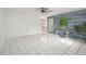 Bright living room with white tile floors, modern ceiling fan, and an accent wall at 4925 Silk Oak Dr, Sarasota, FL 34232