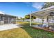 Spacious backyard featuring a white fence, covered deck, and a screened-in lanai at 512 Whitfield Ave, Sarasota, FL 34243