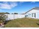 Enclosed backyard featuring a white fence, lush lawn, and access door at 512 Whitfield Ave, Sarasota, FL 34243