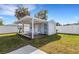 Backyard shed with small deck, pergola, and a white fence on a sunny day at 512 Whitfield Ave, Sarasota, FL 34243