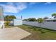 Backyard featuring a shed, concrete pad, white fence, and a grassy yard at 512 Whitfield Ave, Sarasota, FL 34243