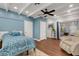 Light blue bedroom with hardwood floors and ceiling fan at 512 Whitfield Ave, Sarasota, FL 34243