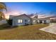 Evening view of a charming ranch house with well-manicured lawn at 512 Whitfield Ave, Sarasota, FL 34243