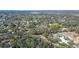 Aerial view of a property surrounded by trees in a neighborhood near tennis courts and open green spaces at 5180 Meldon Cir, Sarasota, FL 34232