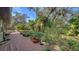 Backyard featuring a deck, tropical plants, and mature trees at 5180 Meldon Cir, Sarasota, FL 34232