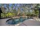 Backyard featuring a screened-in pool with mature trees at 5180 Meldon Cir, Sarasota, FL 34232