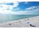 Aerial view of beach with people relaxing under umbrellas at 527 Sutton Pl # T-12, Longboat Key, FL 34228