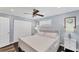 Bright bedroom with a white platform bed, ceiling fan, and dark floors at 527 Sutton Pl # T-12, Longboat Key, FL 34228