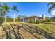 Lush backyard with mature palm trees, manicured hedges, and a screened in lanai at 5507 Country Lakes Trl, Sarasota, FL 34243