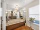 Luxurious bathroom with soaking tub, and a large mirror reflecting the vanity and the updated light fixture at 5507 Country Lakes Trl, Sarasota, FL 34243