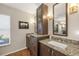 Bathroom vanity featuring granite counters, updated fixtures, dark wood cabinets, and a decorative mirror at 5507 Country Lakes Trl, Sarasota, FL 34243